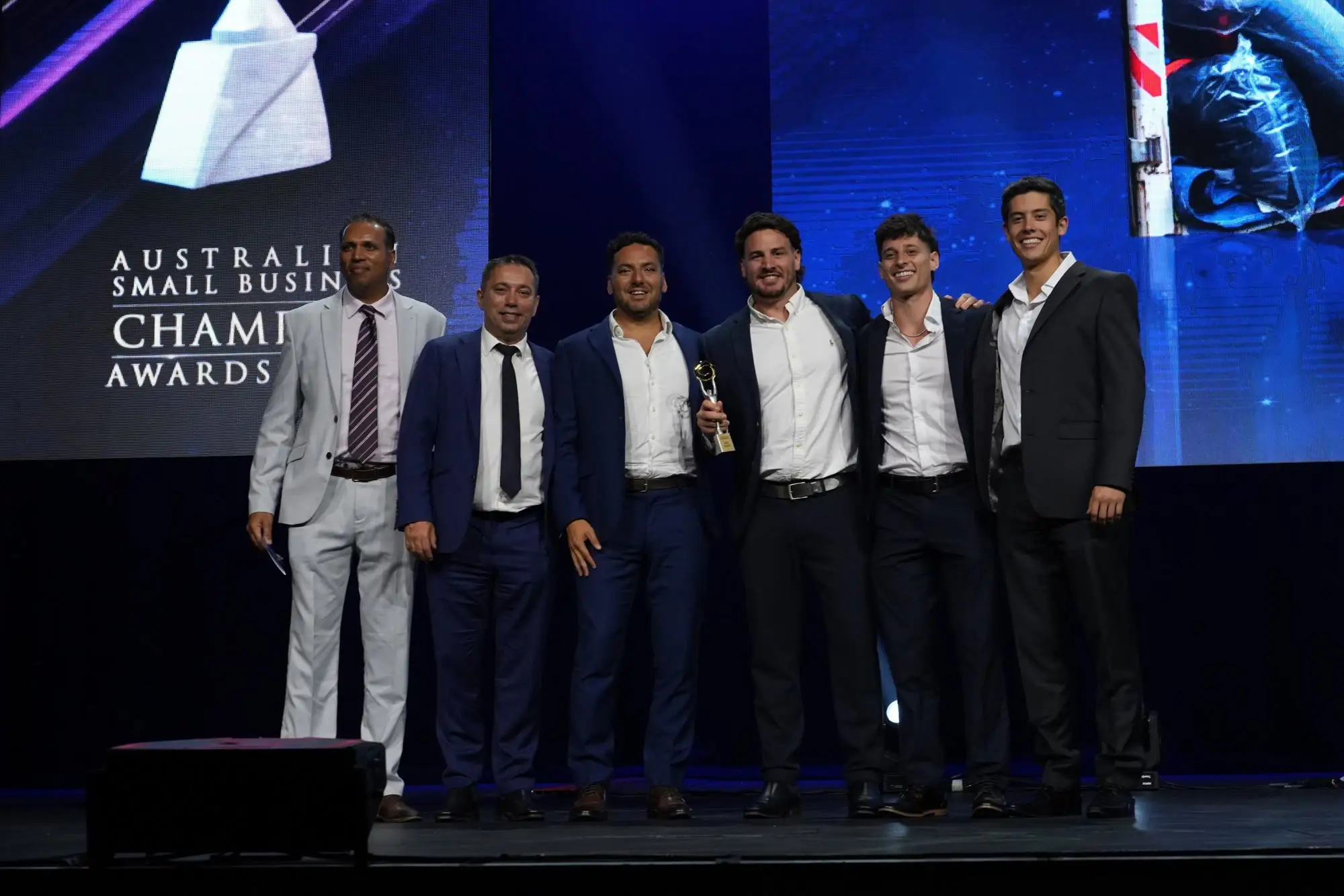 The Removal Brothers team on stage at the 2026 Champion Awards holding the Removalist trophy