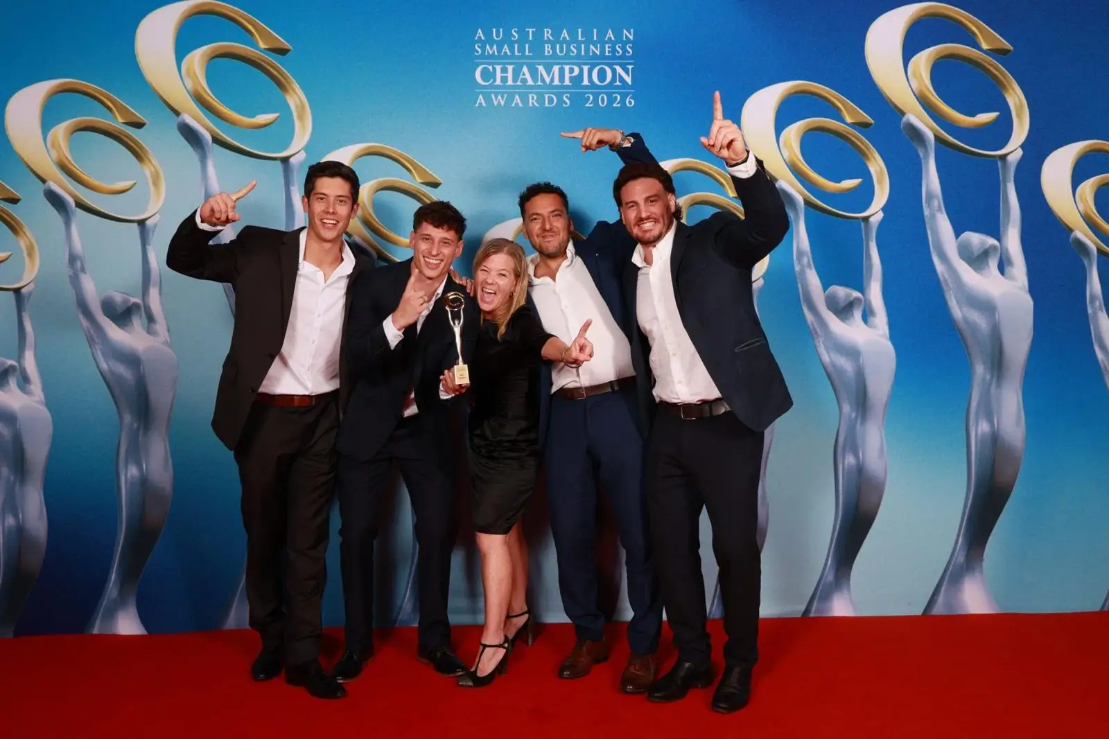 The Removal Brothers team celebrating with the trophy at the awards photo wall