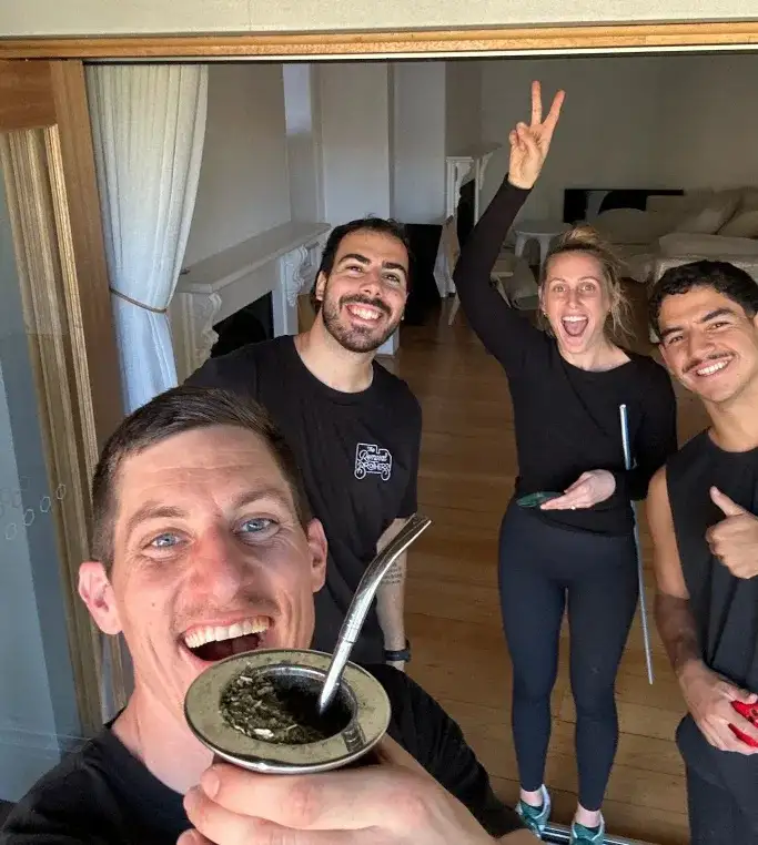 A customer taking a photo with three Removal Brothers crew in an emptied living room